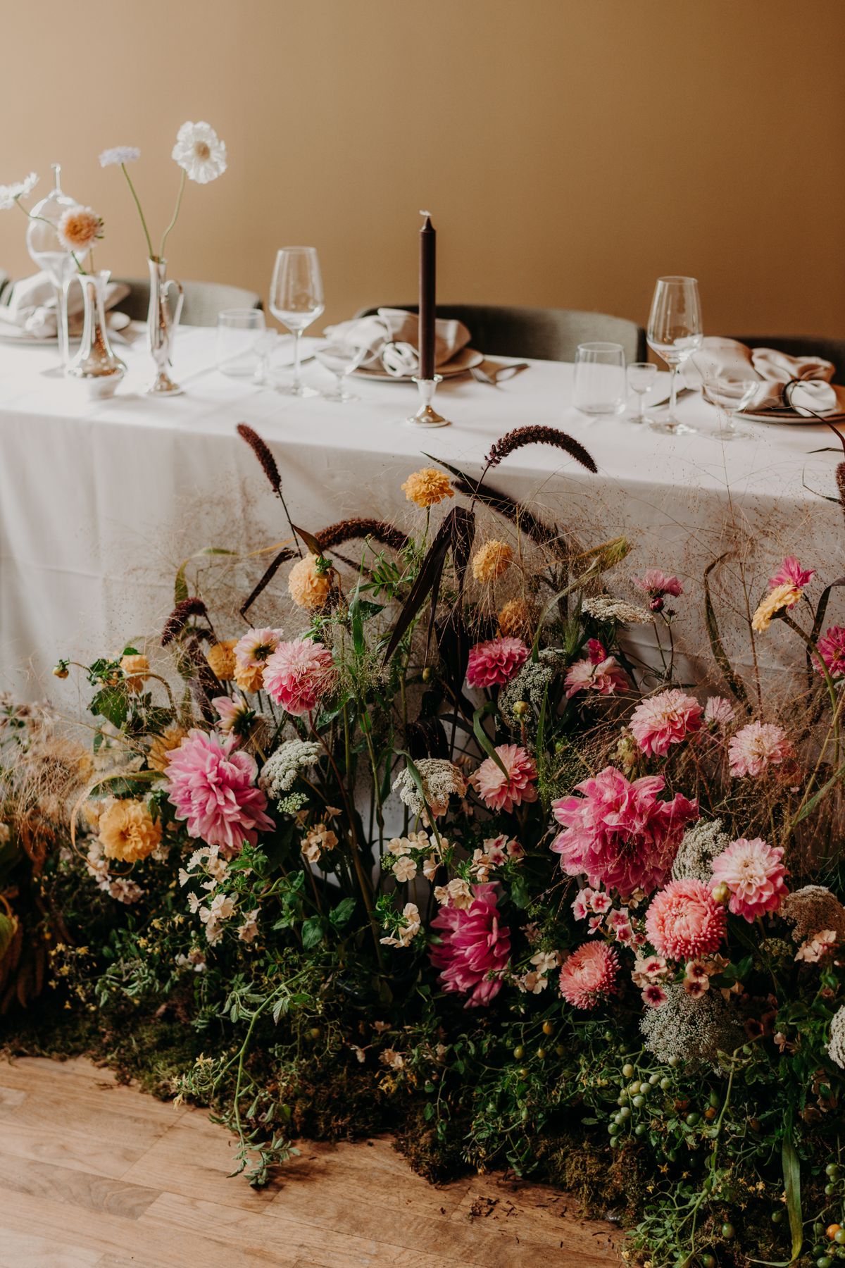 Frodig blomsteruppsättning vid ett dukat bröllopsbord