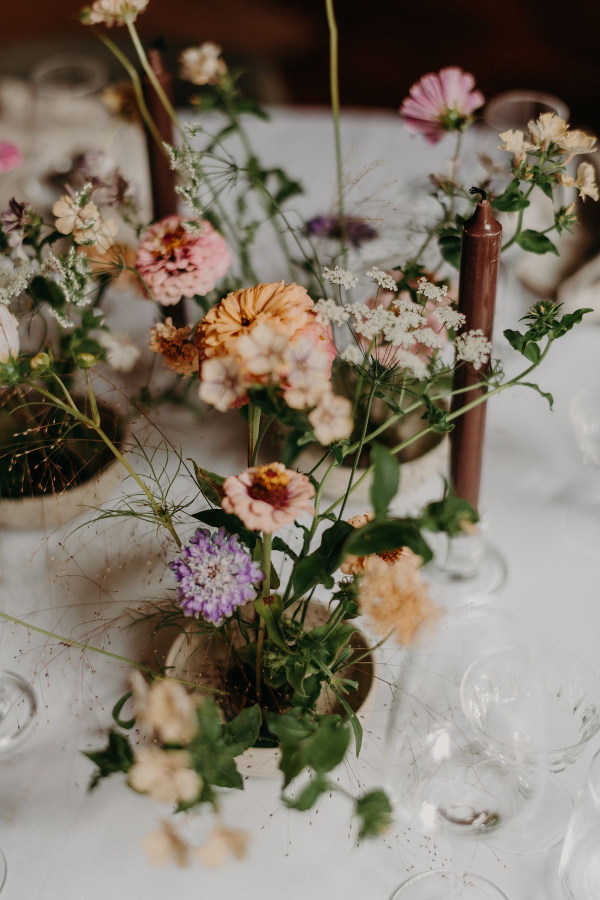Små vaser med säsongens blommor på ett festbord